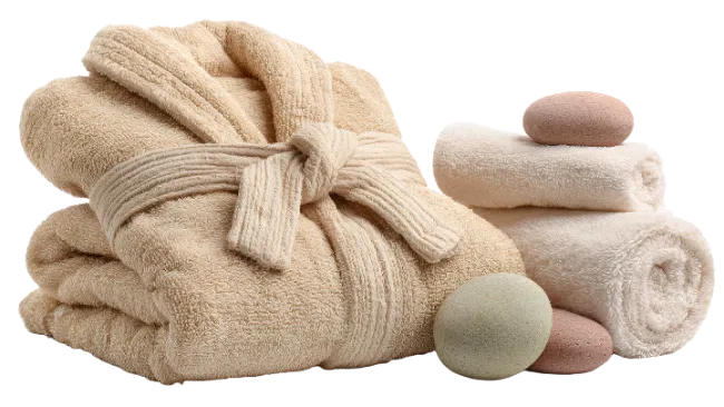 Folded Beige Bathrobe with Towels and Spa Stones