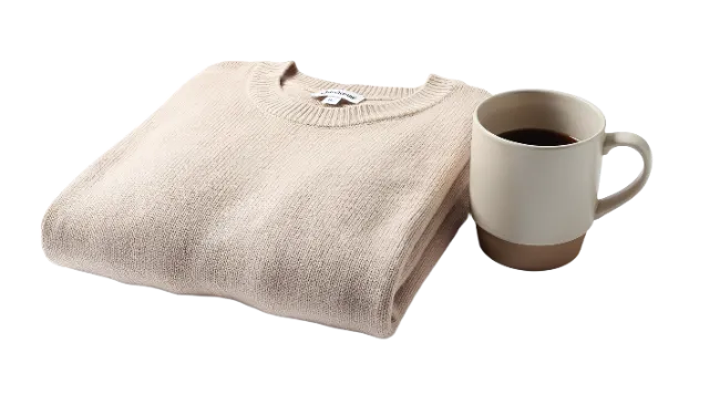 Folded Beige Sweater And Ceramic Coffee Mug