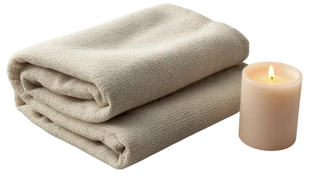Folded Beige Towels and Lit Candle