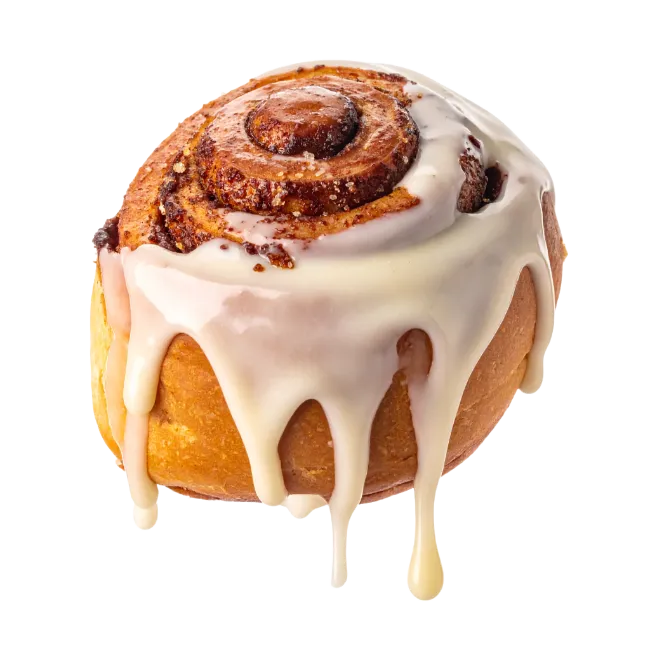 Freshly baked cinnamon roll with white icing drizzle