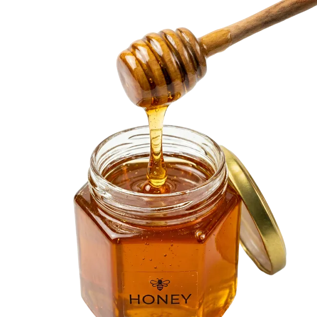 Honey dripping from wooden dipper into glass jar