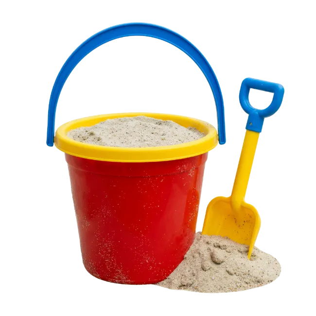 Red beach bucket with yellow shovel and sand