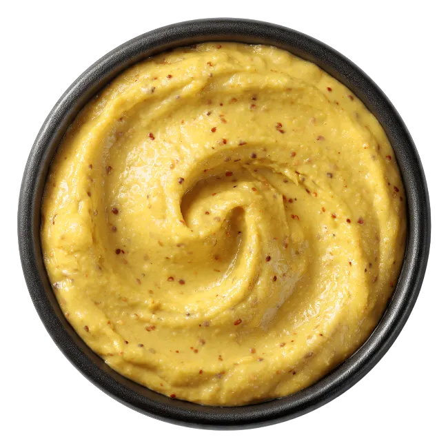 Yellow mustard sauce in a black bowl